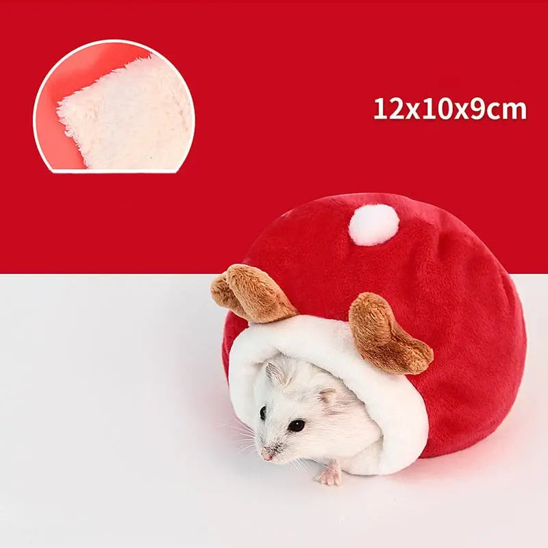 Girafe avec un chapeau de Père Noël et une boule rouge à l’intérieur d’une maison douillette en coton pour votre petit compagnon