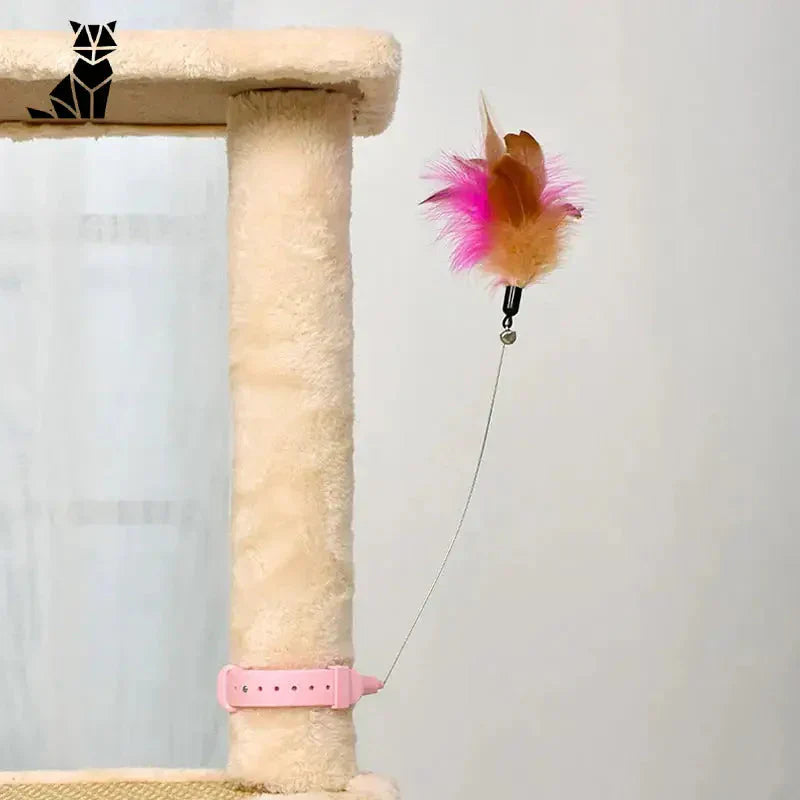 Un chat joue avec un jouet dans un arbre à chat - Jouer ensemble avec CatyPlume